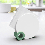 round napkin holder muted green and white in kitchen